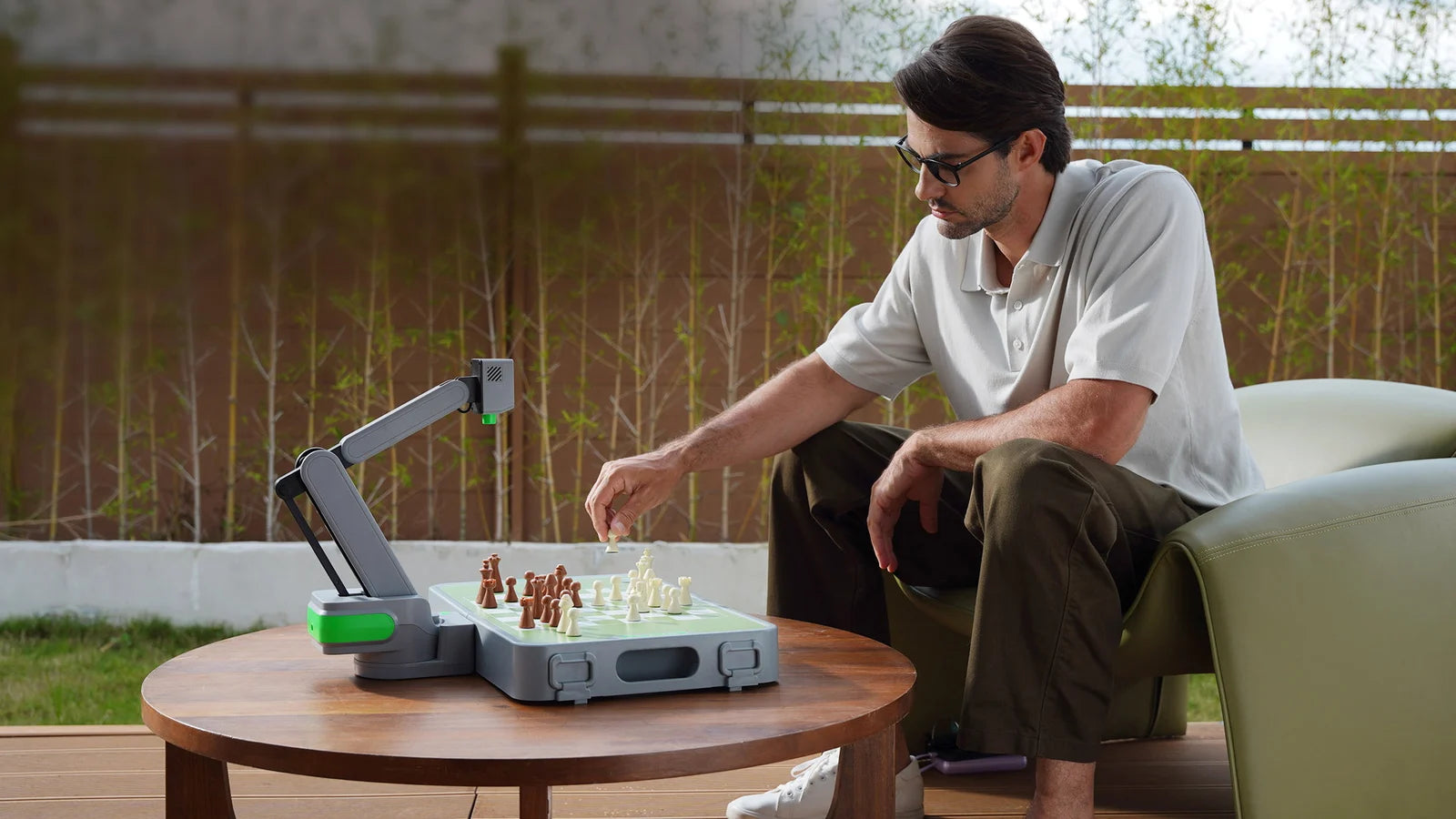 A player moving a real chess piece beside the Cynus robotic board