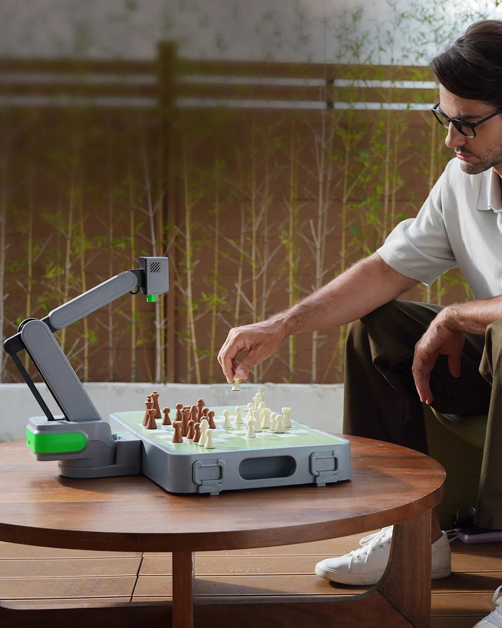 A player moving a real chess piece beside the Cynus robotic board